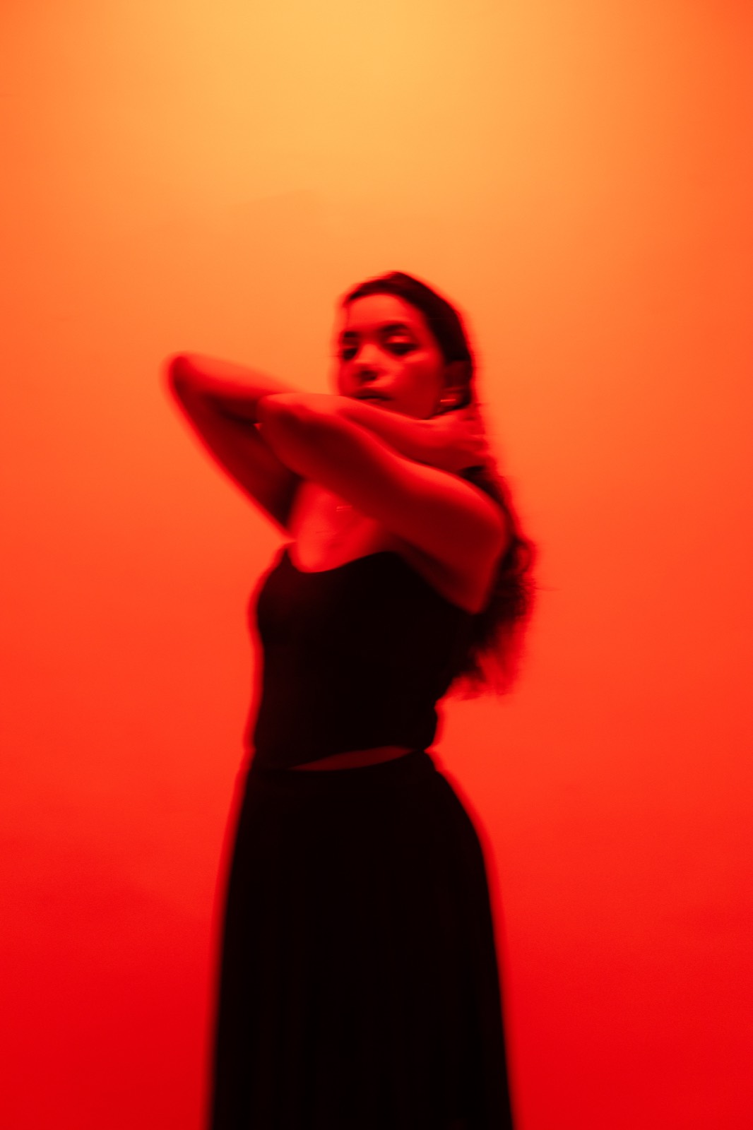 Cobalt Pleated Set — the skirt caught in movement under the red light