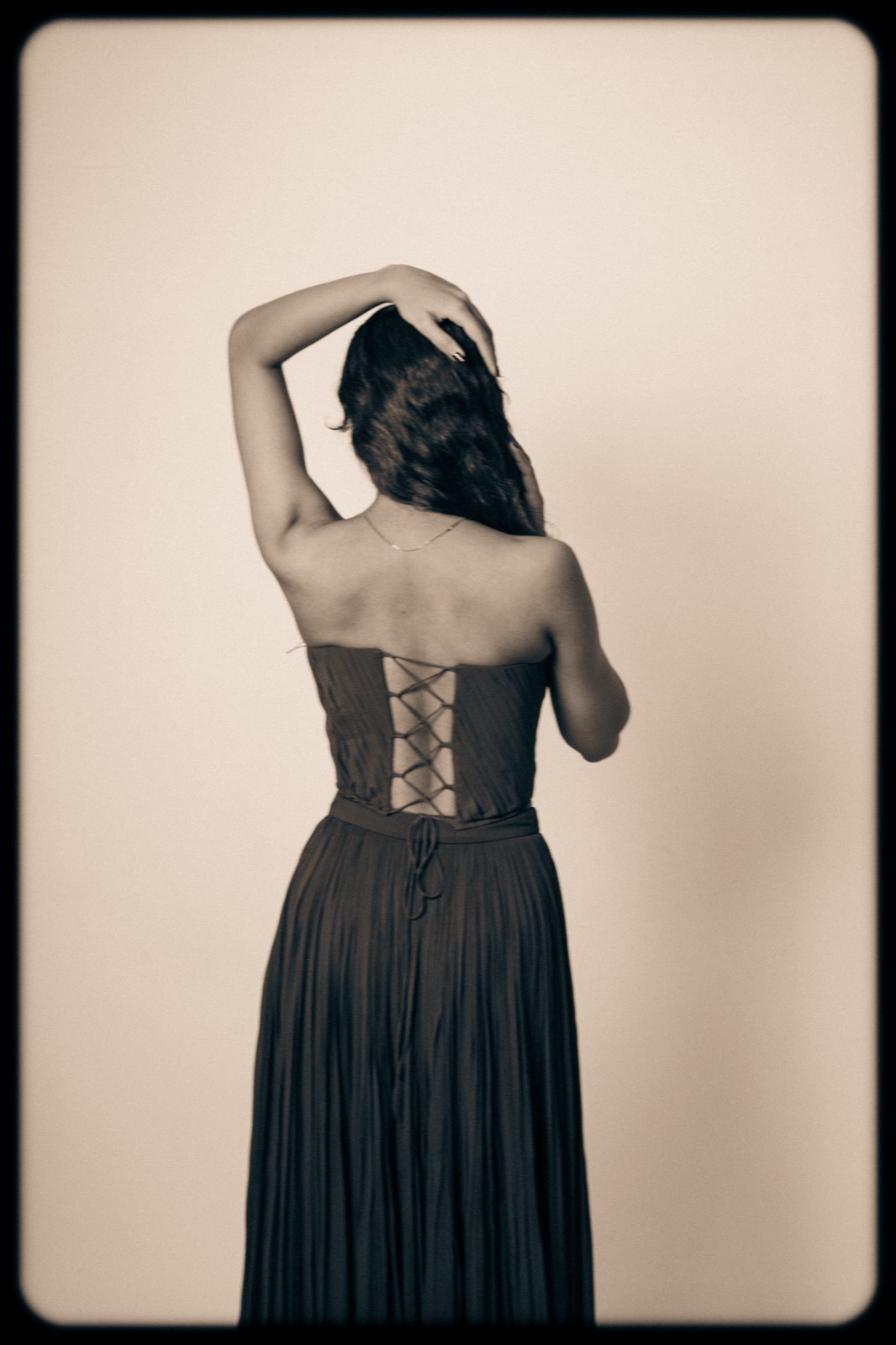 Cobalt Pleated Set — the corset laced at the back, photographed in monochrome