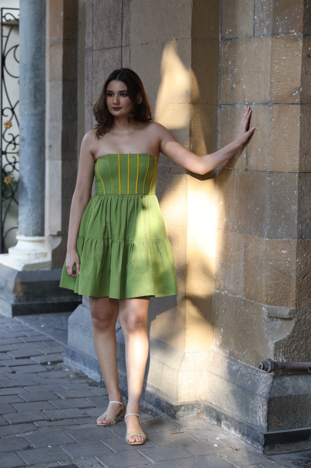 Green Tiered Mini — full length, a green strapless mini with a topstitched bodice, against a sunlit stone colonnade