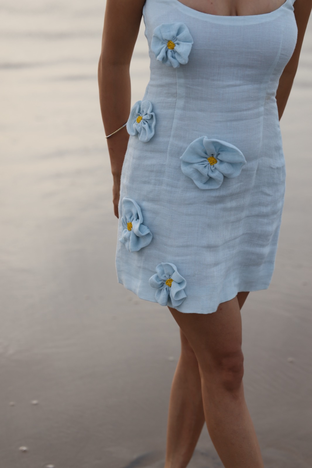 Hibi Blue — close on the pale blue colourway, showing the hand-set floral appliqué