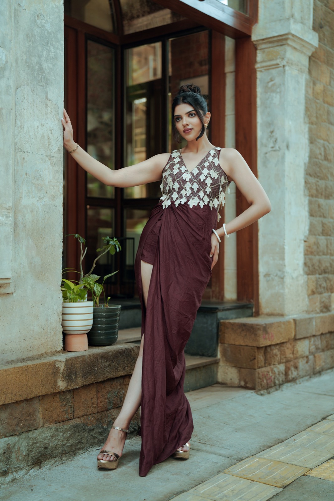 Ivory Drop — a leaf-embroidered ivory bodice over a draped maroon skirt, in a doorway