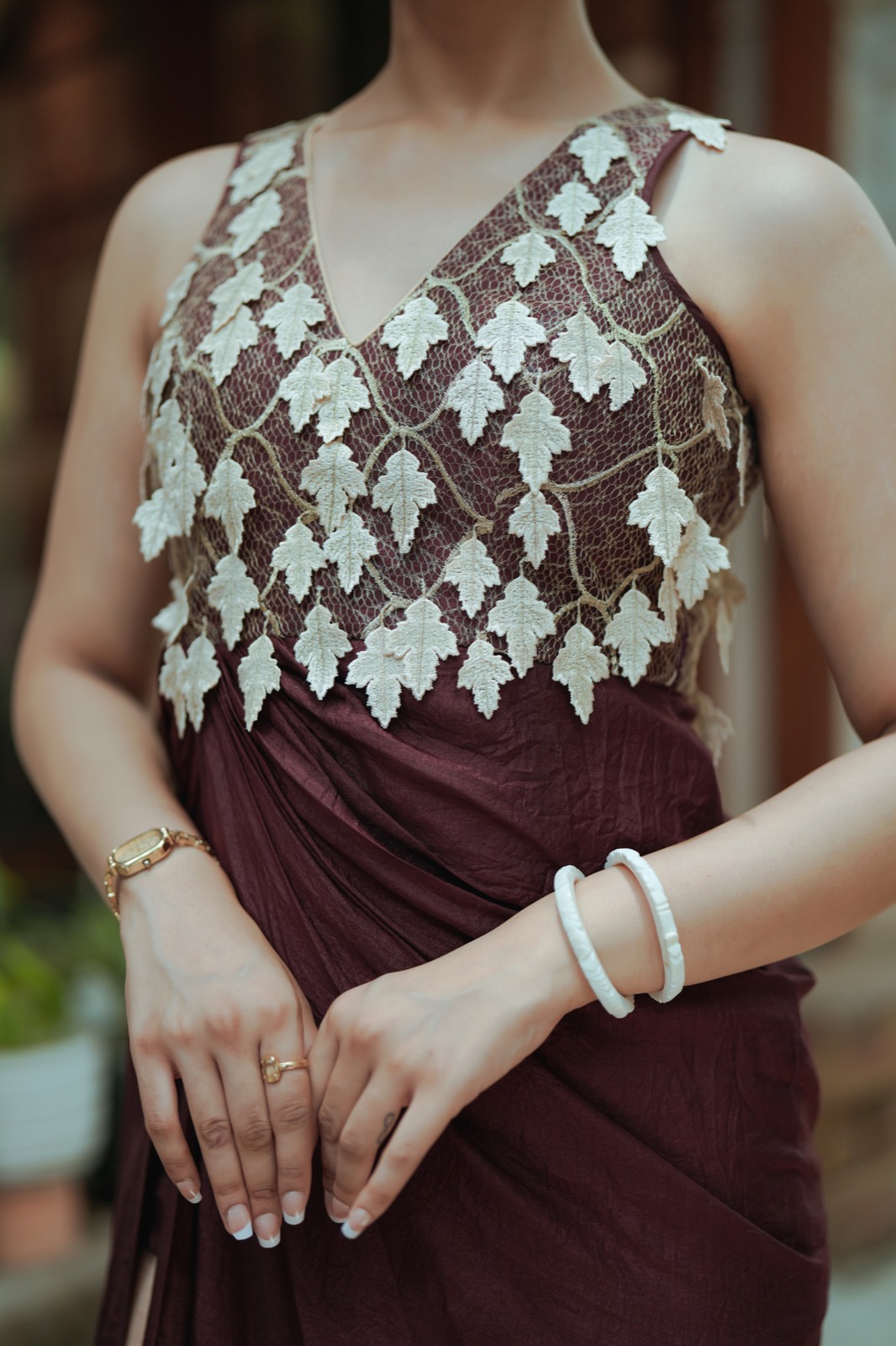 Ivory Drop — the leaves meeting the draped waist, hands resting together