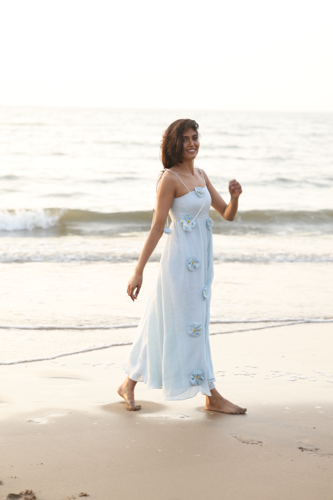 Powder Blue Bloom — pale blue maxi with three-dimensional fabric flowers, on the beach at golden hour