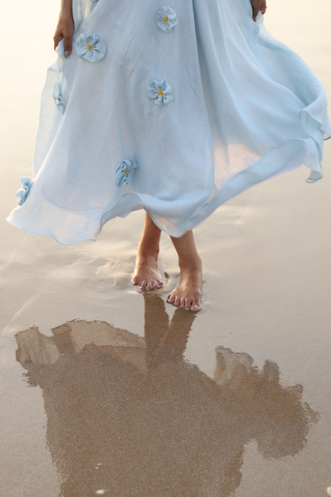 Powder Blue Bloom — the appliquéd hem lifted at the water's edge