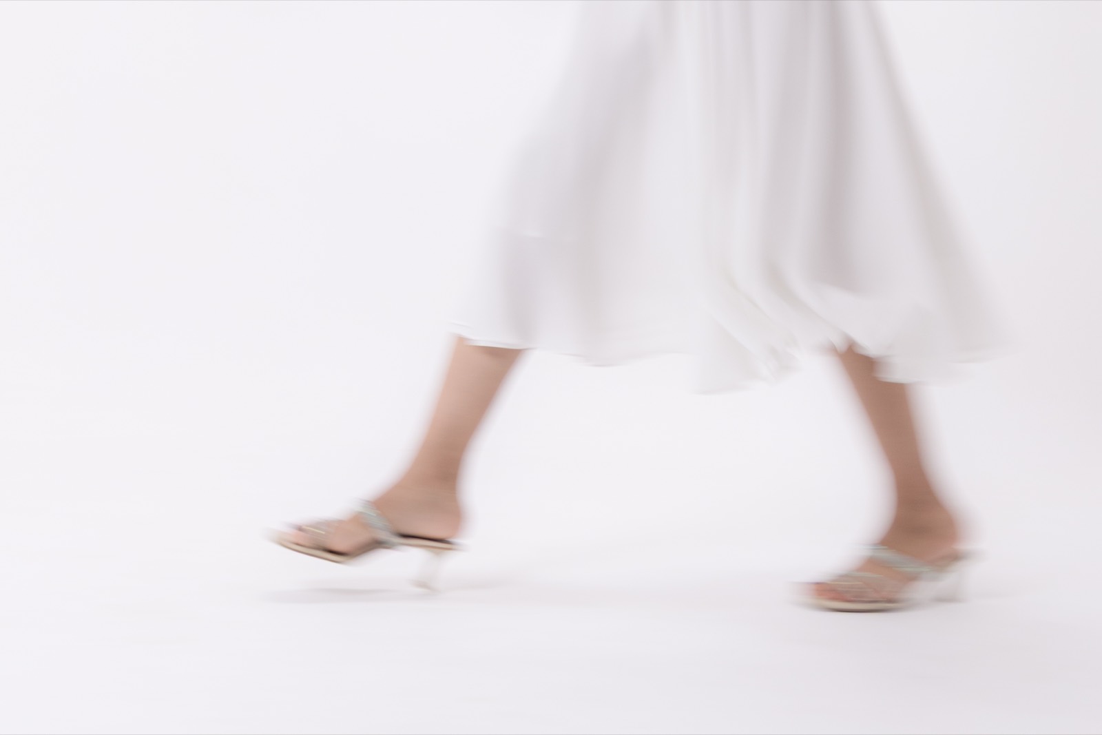 White Halter Midi — the hem and heels caught mid-stride