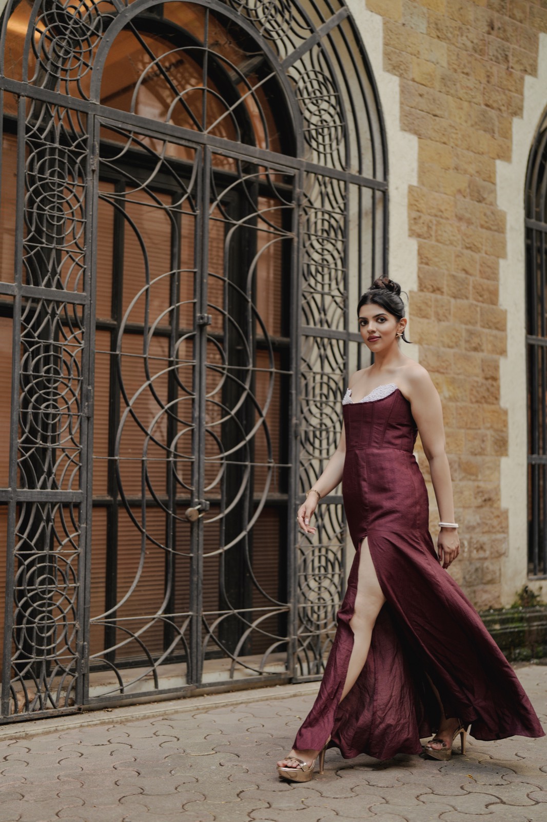 Claret Column — walking past the iron gates, the slit opening as she moves