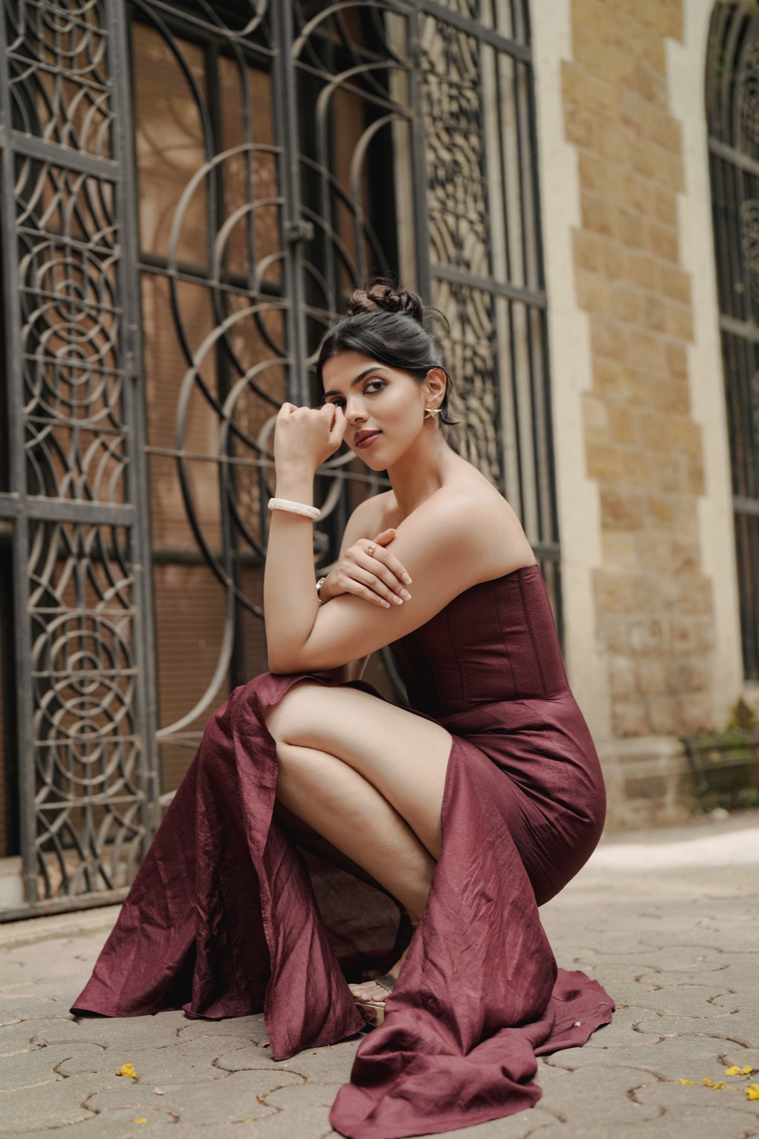 Claret Column — crouched on the pavement, the skirt spread out around her